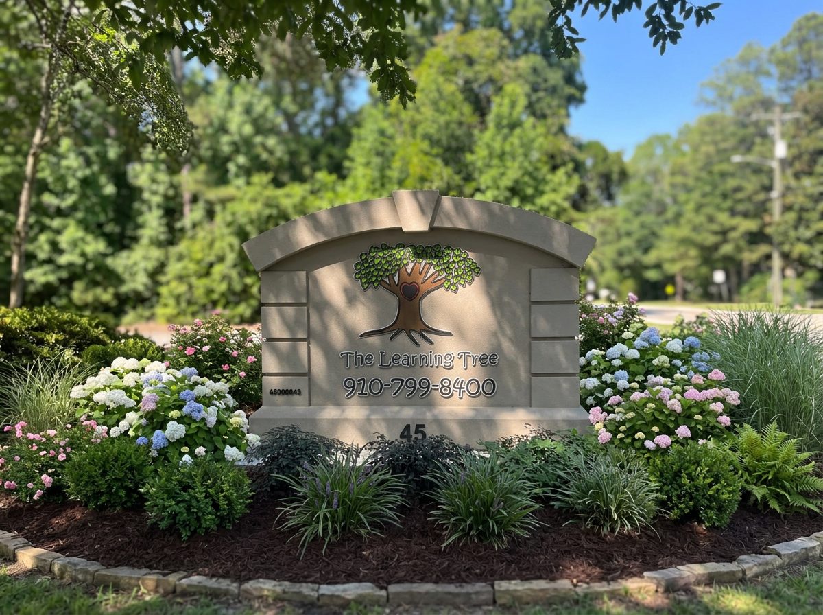 The Learning Tree sign surrounded by a colorful flower garden